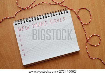 New Years Goals On A Notebook On A Wooden Table With A Lace Horyzontally
