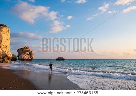 A Barefooted Boy Plays At The Beach Againt The Petra Tou Romiou (aphrodite's Birthplace) Rocks Bathe