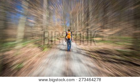 Traveler hiking through deep forest in the mountains - blurred motion techique used to convey fast paced movement
