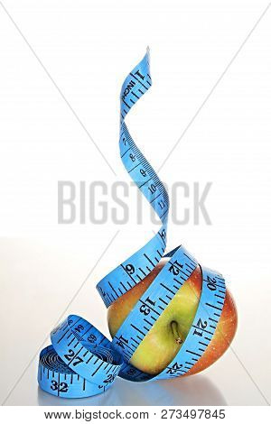 Apple With Tape Measure On White Background Stock Photo