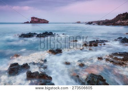 Dramatic Beautiful Sunset On A Rocky Coast. Long Exposure Photography