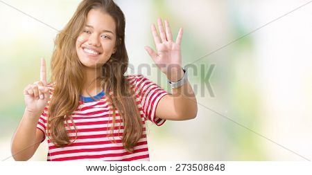 Young beautiful brunette woman wearing stripes t-shirt over isolated background showing and pointing up with fingers number six while smiling confident and happy.