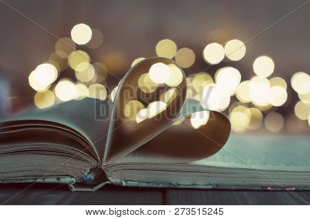 An Open Book With Heart Shaped Pages And Bokeh Lights