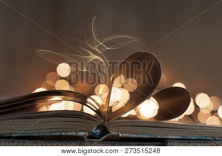 An Open Book With Heart Shaped Pages And Bokeh Lights