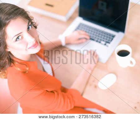 Attractive Woman Sitting At Desk In Office, Working With Laptop Computer