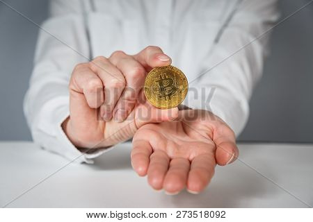 Golden Bitcoin In A Man Hand, Digitall Symbol Of A New Virtual Currency