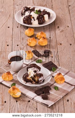Chocolate Profiteroles With Whipped Cream On White Dish.