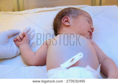 Doctor Holding Newborn Child's Hand In Hospital