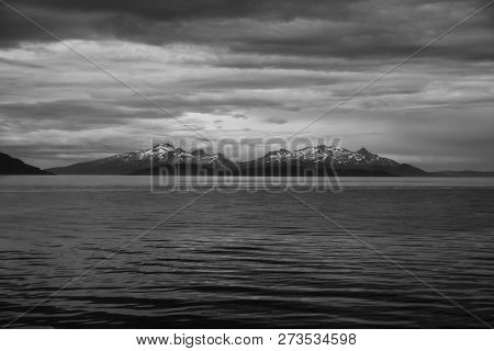 Sea In Hammerfest, Norway. Evening Seascape With Mountain Coast Under Cloudy Sky. Sea Travelling. Ad