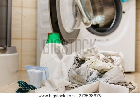 Washing Powder Detergent And Measuring Cup Next To Machine In Bathroom. Household Duties, Clothes La