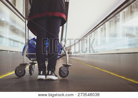 Close Up Woman With Luggage Trolley In Airport Escalator