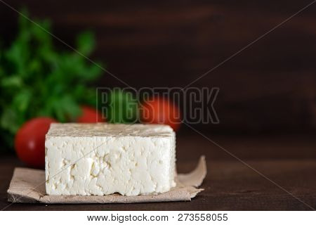 Large Piece Of Feta Cheese On Dark Wooden Table. Selective Focus.
