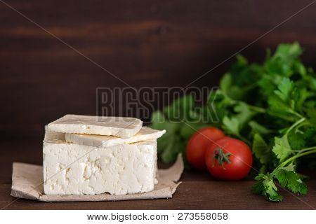 Large Piece Of Feta Cheese On Dark Wooden Table. Selective Focus.