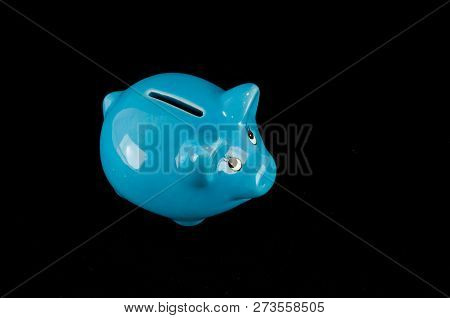 Blue Piggy Bank Or Money Box Isolated On A Black Studio Background