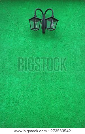 Vivid Green Colored Concrete Wall With A Pair Of Retro Street Lamp, El Calafate, Argentina