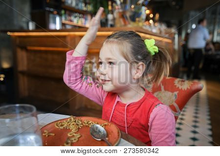 Little Girl Eating Fideua And Smiling In Restaurant