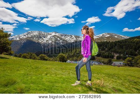 Side Of Woman On Meadow Looking At Snowy Mountain Ready To Hike