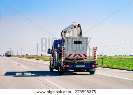 Truck Carrying Trailer With Crane And Garbage Container At The Asphalt Road In Slovenia.