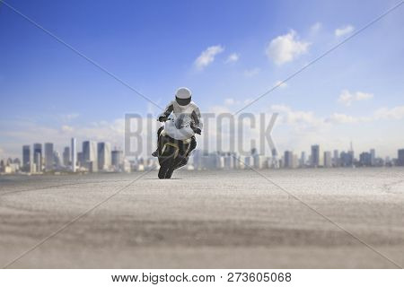 Man Riding Big Motorcycle On Asphalt Highway Against Urban Skyline Background