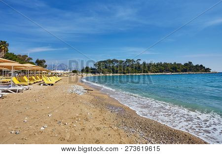 Umbrellas And Empty Beach Chairs On The Beach Near Blue Sea Water, Kemer, Turkey, Mediterranean Sea.