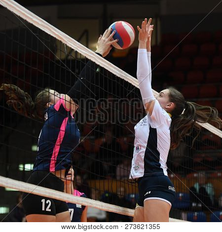 KAPOSVAR, HUNGARY â DECEMBER 2, 2018: Viktoria Kalmar (in white) in action at a Hungarian National Championship volleyball game between Kaposvar (white) and Palota VSN (blue) in Sportcsarnok Kaposvar.