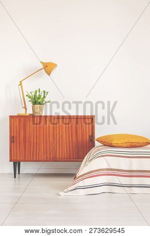 Yellow Lamp And Plant In Pot On Vintage Cabinet In Elegant Bedroom Interior, Real Photo With Copy Sp