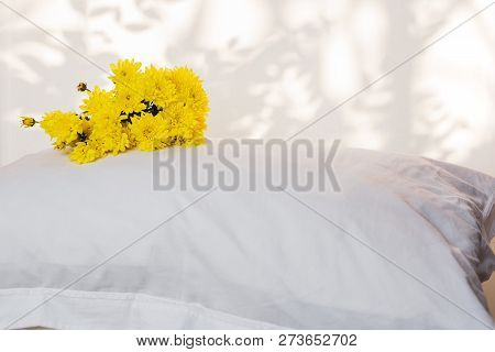 Pillows And Beautiful Yellow Flower On Top In The Bed Room.