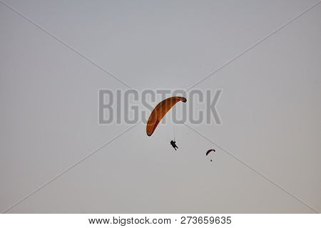 Paraglider Silhouette Flying Over Misty Mountain Valley In Beautiful Warm Sunset Colors - Sport, Act