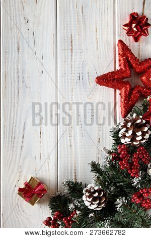 Spruce Branches, Cones And Red Berries On A White Wooden Background. Background For Christmas And Ne