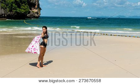 Teen Girl Standing On Sand On Beautiful Tropical Beach With Pink Beach Towel