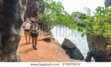 Mother And Daughter In Shorts Walking On Path Next To Sea