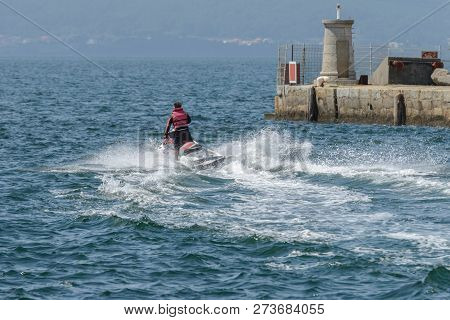 Young Man Riding A Jet Ski In The Sea