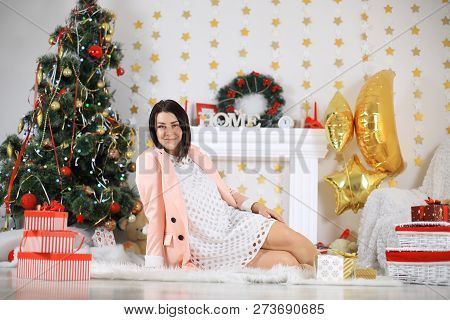 Happy Young Lady With Curlu Hair Gifts By The Fireplace Near The Christmas Tree. New Year Concept.