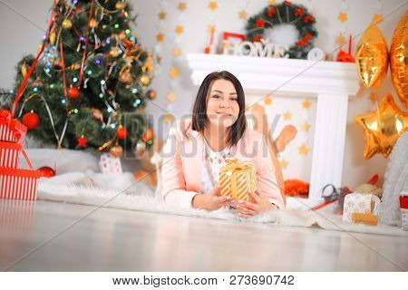 Happy Young Lady With Curlu Hair Gifts By The Fireplace Near The Christmas Tree. New Year Concept.
