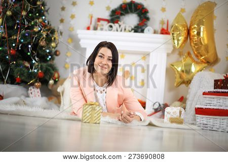 Happy Young Lady With Curlu Hair Gifts By The Fireplace Near The Christmas Tree. New Year Concept.