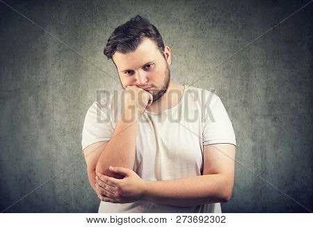 Casual Adult Obese Man Leaning On Hand Having Problem And Looking Unhappy On Gray Background