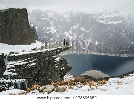 Trolltunga, Norway - May 04 2018: Couple In Love On Troll Tongue During Marriage Proposal , Trolltun