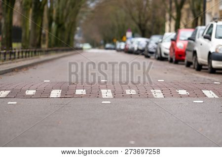 Speed Bump On Emptry Street In Warsaw, Poland, Cars On One Side Of The Street, Challenge Symbol