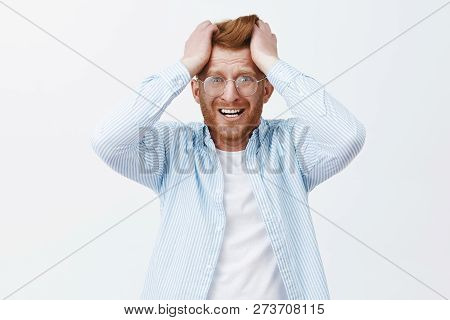 Studio Shot Of Upset Redhead Man In Despair And Shook, Feeling Distressed Losing Company, Pulling Ha