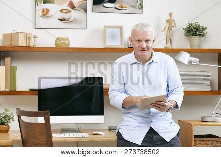 Portrait Of Positive Mature It Engineer With Digital Tablet Standing At Hie Workplace