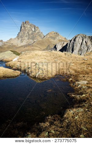 Midi Dossau Peak reflected in a lake. Ossau Valley, Pyrenees National Park, Pyrenees, France.