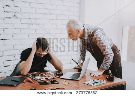 Two Men Repairing Hardware Equipment In Workshop. Repair Shop. Worker With Tools. Computer Hardware.