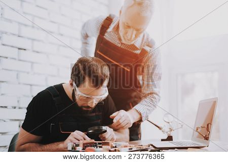 Two Men Repairing Hardware Equipment In Workshop. Repair Shop. Worker With Tools. Computer Hardware.