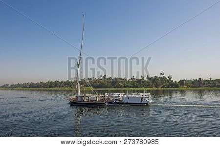 Traditional Egyptian Felluca Sailing Boat Traveling On Nile River Through Rural Countryside Landscap