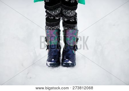 Croped Image Of Kid Boots Walk In Snow. Closeup Of Shoes.