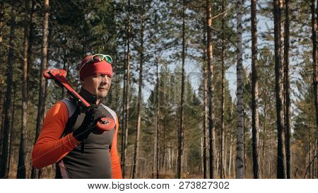 Training An Athlete On The Roller Skaters. Biathlon Ride On The Roller Skis With Ski Poles, In The H