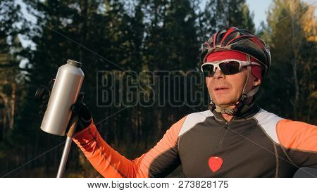 Training An Athlete On The Roller Skaters. Biathlon Ride On The Roller Skis With Ski Poles, In The H