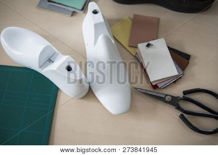 Two White Plastic Last Shoe On Rubber Secondary Cut Cutting Mat, The Equipment Used For Shoe Design.