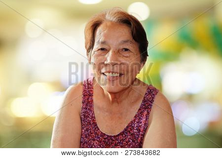 Portrait Of Asian Elderly Woman Smiling With Colorful Bokeh Background, Happy And Good Mood Concept