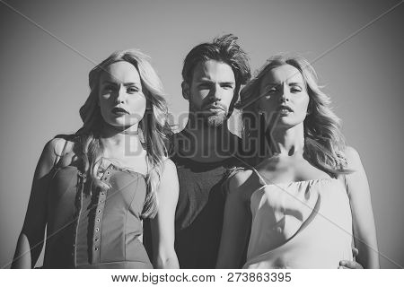 Twins Women With Macho On Blue Sky Background. Family Trust, Polygamy, Betrayal, Swinger. Love Trian